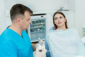 dokter orthodontist legt uit naar haar geduldig wat hij zullen Doen foto