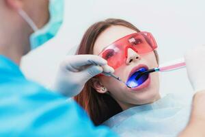 dokter orthodontist onderzoekt de geduldig na poetsen zijn tanden foto