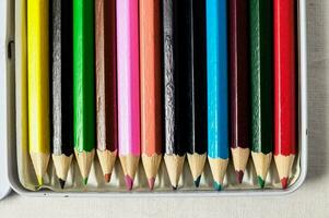 een doos van gekleurde potloden in een wit geval foto