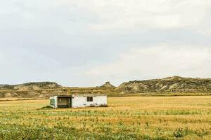 een klein huis in de midden- van een veld- foto