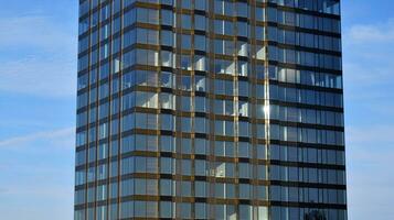 structureel glas muur reflecterend blauw lucht. abstract modern architectuur fragment foto