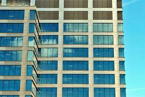 structureel glas muur reflecterend blauw lucht. abstract modern architectuur fragment foto