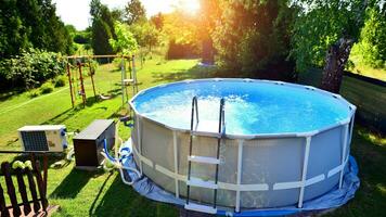 zwemmen zwembad met metaal kader voor huis en tuin. kader zwemmen zwembad in de tuin. tuin in de achtergrond. zomer vakantie pret en recreatie. foto