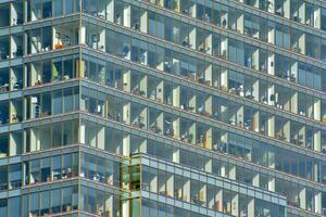 structureel glas muur reflecterend blauw lucht. abstract modern architectuur fragment foto