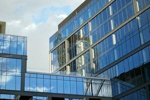 structureel glas muur reflecterend blauw lucht. abstract modern architectuur fragment foto