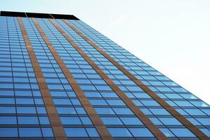 structureel glas muur reflecterend blauw lucht. abstract modern architectuur fragment. foto