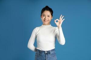 portret van mooi Aziatisch vrouw poseren Aan blauw achtergrond foto