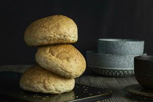 een stack van drie broodjes bun Aan een zwart dienblad foto