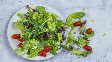 een bord met een salade en tomaten Aan het foto