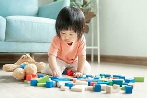 gelukkig Azië kinderen Speel en leren speelgoed- blokken.familie is gelukkig en opgewonden in de huis. dochter hebben pret uitgeven tijd, werkzaamheid, ontwikkeling, iq, gelijk, meditatie, brein, spieren, essentieel vaardigheden. foto