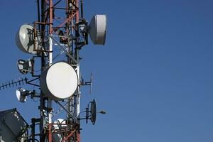 telecommunicatieverbinding antenne met meerdere satelliet tegen de blauw lucht foto