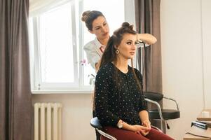 kapper aan het doen haar- stijl voor vrouw. concept van mode en schoonheid foto