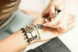 jong vrouw mehendi artiest schilderij henna- Aan de hand- foto