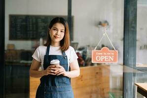 opstarten geslaagd klein bedrijf eigenaar mkb vrouw staan met tablet in cafe restaurant. vrouw barista foto