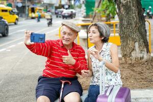 senior Chinese toerist met zijn vriend Europese poses gelukkig en nemen een foto selfie Aan wazig van stad achtergrond.