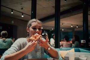 een vrouw aan het eten pizza in de kantoor foto