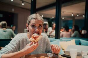 een vrouw aan het eten pizza in de kantoor foto