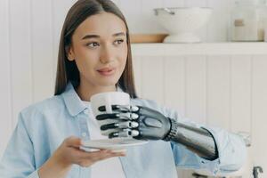 een jong vrouw met een bionisch prothetisch hand- bewonderend houdt een beker, een fusie van de mensheid en Geavanceerd robotica foto