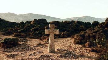 een eenzaam steen kruis staand in de uitgestrektheid van de woestijn foto