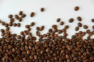 koffie bonen verspreide in de omgeving van Aan een wit achtergrond foto