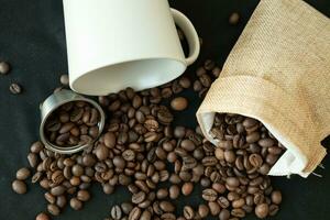 koffie bonen in navulbaar koffie capsules, koffie Tassen en in de omgeving van Aan een zwart achtergrond. foto