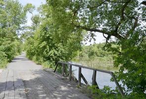 prachtig staande oude houten brug over rivier in gekleurde achtergrond foto