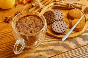 cacao, koekjes en kaneel stokjes Aan houten tafel. foto