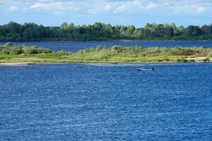 rivier- landschap. blauw diep water met snel huidig. groen struikgewas Aan andere kust. foto