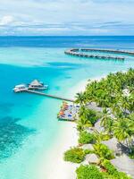luxe eiland landschap in Maldiven met boten en perfect blauw zee water, palm bomen en water villa's. tropisch strand net zo antenne landschap, visie van drone. mooi natuur landschap in Maldiven eiland foto