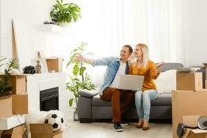 paar in beweging in samen ontspannende Aan sofa bankstel met laptop computer en dozen foto