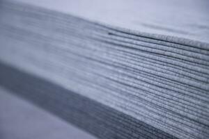 gestapeld gevouwen grijs kleding stof oppervlakte structuur achtergrond behang. selectief focus foto