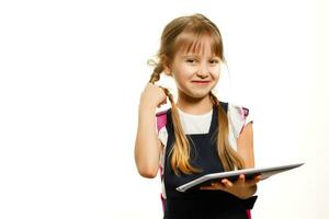 de weinig meisje gebruik makend van de tablet Aan de wit muur achtergrond foto