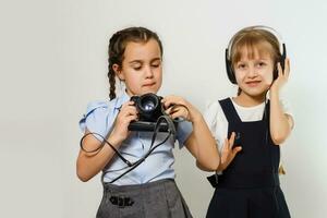 twee nieuwsgierig vriendelijk schoolmeisjes aan het kijken foto's Bij breken foto