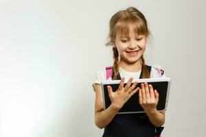 weinig meisje gebruik makend van tablet computer. geïsoleerd Aan wit achtergrond. foto