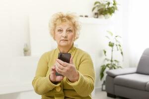 van streek ouderen vrouw gebruik makend van tintje scherm mobiel voor nemen selfie of maken video telefoontje foto