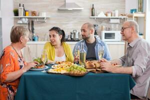 familie zittend Bij dining tafel. moeder en dochter hebben een gesprek gedurende lunch. smakelijk gekruid aardappelen. foto