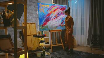 vrouw schilder werken Aan abstract schilderij in studio. foto