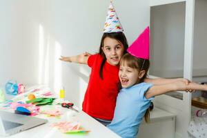 kinderen online verjaardag feest. weinig meisjes in jurken, hoed vieren vakantie met vrienden. conferentie, filmpje telefoontje in laptop, computer. quarantaine, coronavirus pandemisch covid19. foto