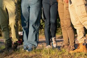 een groep van mensen bereid voor een wandeltocht, vervelend stevig schoenen en dik broek naar beschermen hun voeten foto