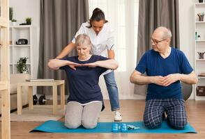 medisch arbeider corrigeren de uitvoering van de opdrachten. huis bijstand, fysiotherapie, gezond levensstijl voor senior oud persoon, opleiding en herstel met professioneel fysiotherapeut foto