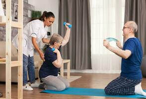 senior paar aan het doen fysiotherapie met dokter. huis bijstand, fysiotherapie, gezond levensstijl voor senior oud persoon, opleiding en herstel met professioneel fysiotherapeut foto