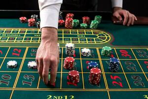 een detailopname levendig beeld van groen casino tafel met roulette, met de handen van croupier en veelkleurig chips. foto