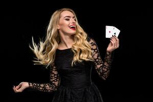 mooi jong vrouw Holding twee aas van kaarten in haar hand- geïsoleerd Aan zwart achtergrond foto