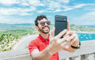 gelukkig toerist Mens nemen een selfie Bij een strand gezichtspunt. knap Mens nemen een selfie Bij de gezichtspunt van san Juan del sur foto