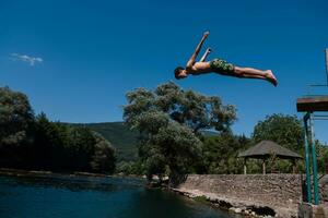 een Mens in een zwempak is jumping in de water foto