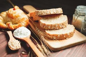 verschillende soorten brood met voeding volle granen op houten achtergrond. voedsel en bakkerij in keukenconcept. heerlijk ontbijt gouemet en maaltijd. koolhydraten biologisch voedsel keuken huisgemaakt foto