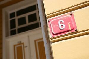 huis aantal zes. decoratief belettering Aan een steen muur. foto