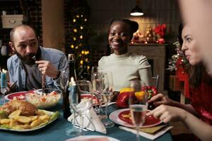 feestelijk persoon bijwonen Kerstmis avondeten vieren seizoensgebonden vakantie met familie bijeenkomst Bij huis en aan het eten kip gebraden maaltijd. groep van blij vrienden genieten van traditioneel Kerstmis viering. foto