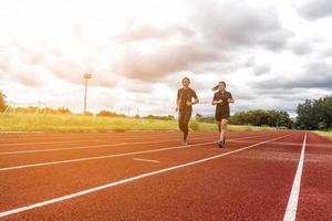 twee lopers joggen op het circuit, sport en sociale activiteit concept foto