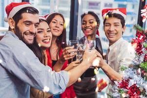 groep zakelijke diversiteit collega teamwerk vieren voor nieuwjaarsfeest in moderne stedelijke kantoorachtergrond. vrienden die samen genieten van een feestje met alcoholivd. multi-ethiek mensen levensstijl foto